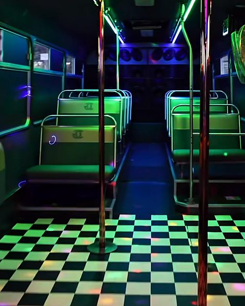 Inside the Gold Class party bus: LED-lit aisle, dance pole and checkerboard dance floor