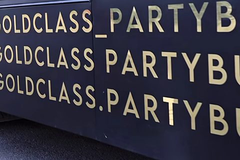 Gold lettering on the side of the bus: the goldclass_partybus social handles