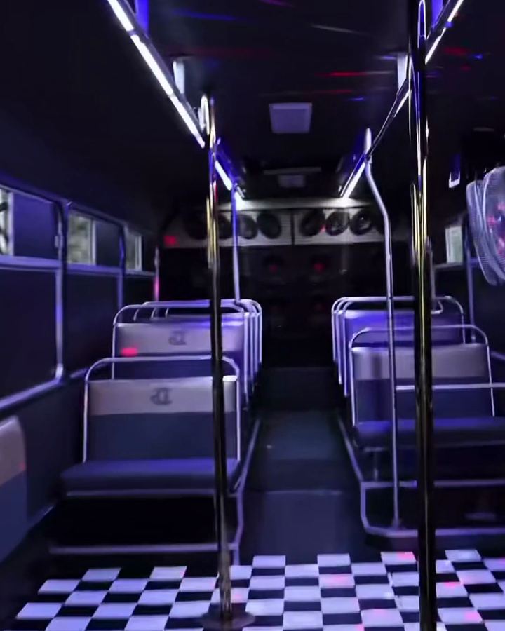 Inside the Gold Class party bus: LED strips along the ceiling, poles and a checkerboard floor