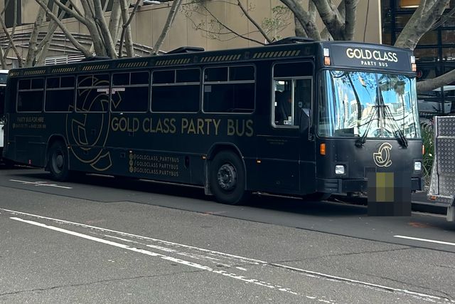 The black Gold Class party bus parked on a Sydney street, GOLD CLASS PARTY BUS along its side in gold