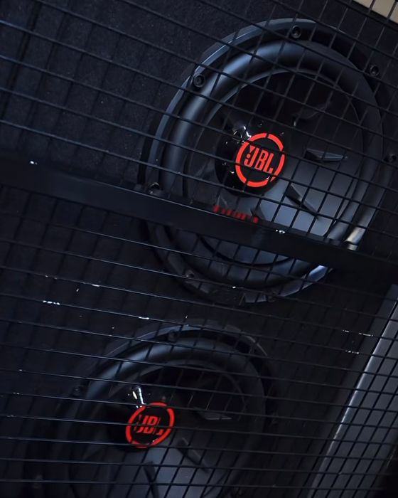 Two JBL speakers with red logos behind a black mesh grille on board